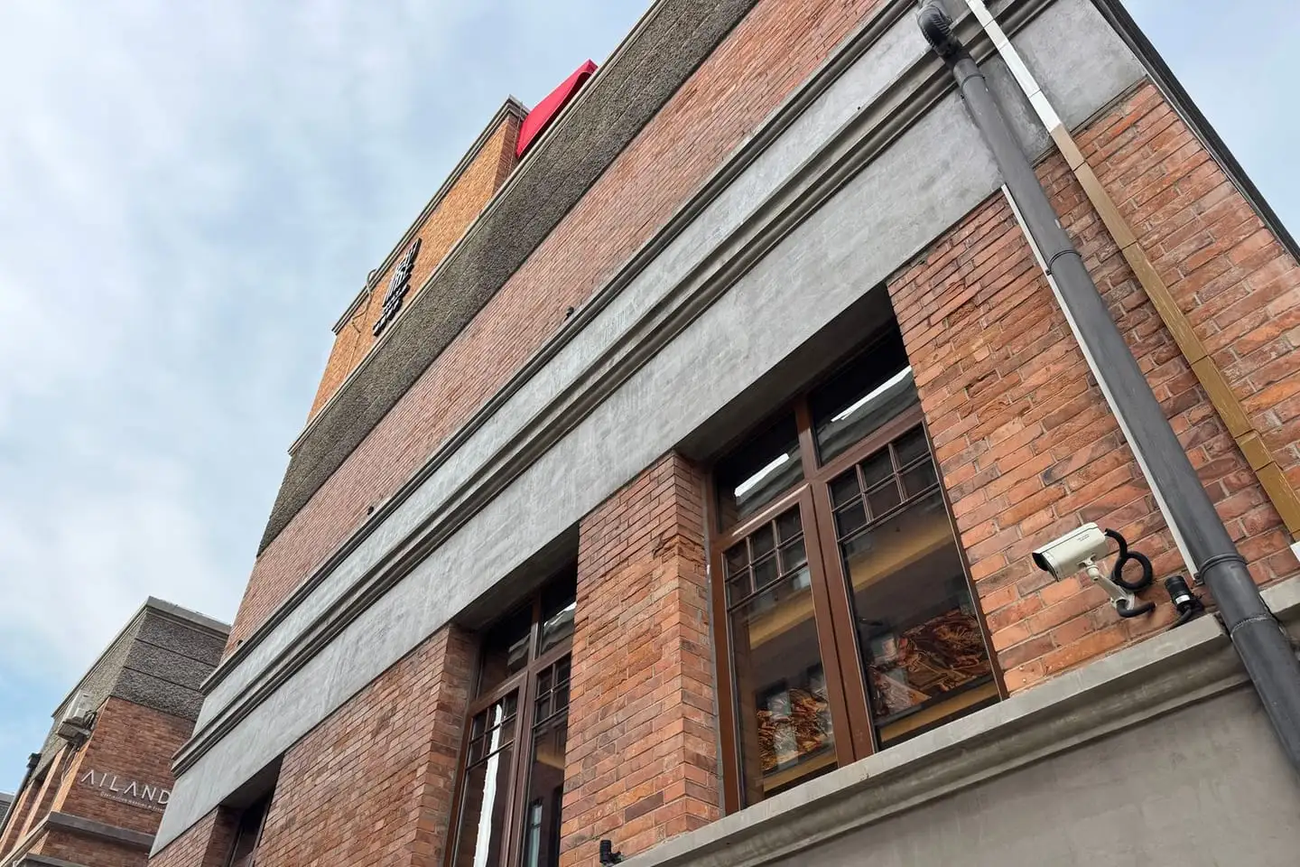 A red brick commercial building facade with regular windows, the kind of asset sold at a commercial auction.